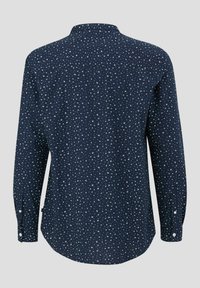 Langarmige marineblauwe blouse met een verspreid wit bloemenpatroon, met knoopmanchetten en een ronde zoom. Zacht materiaal met een gladde textuur.