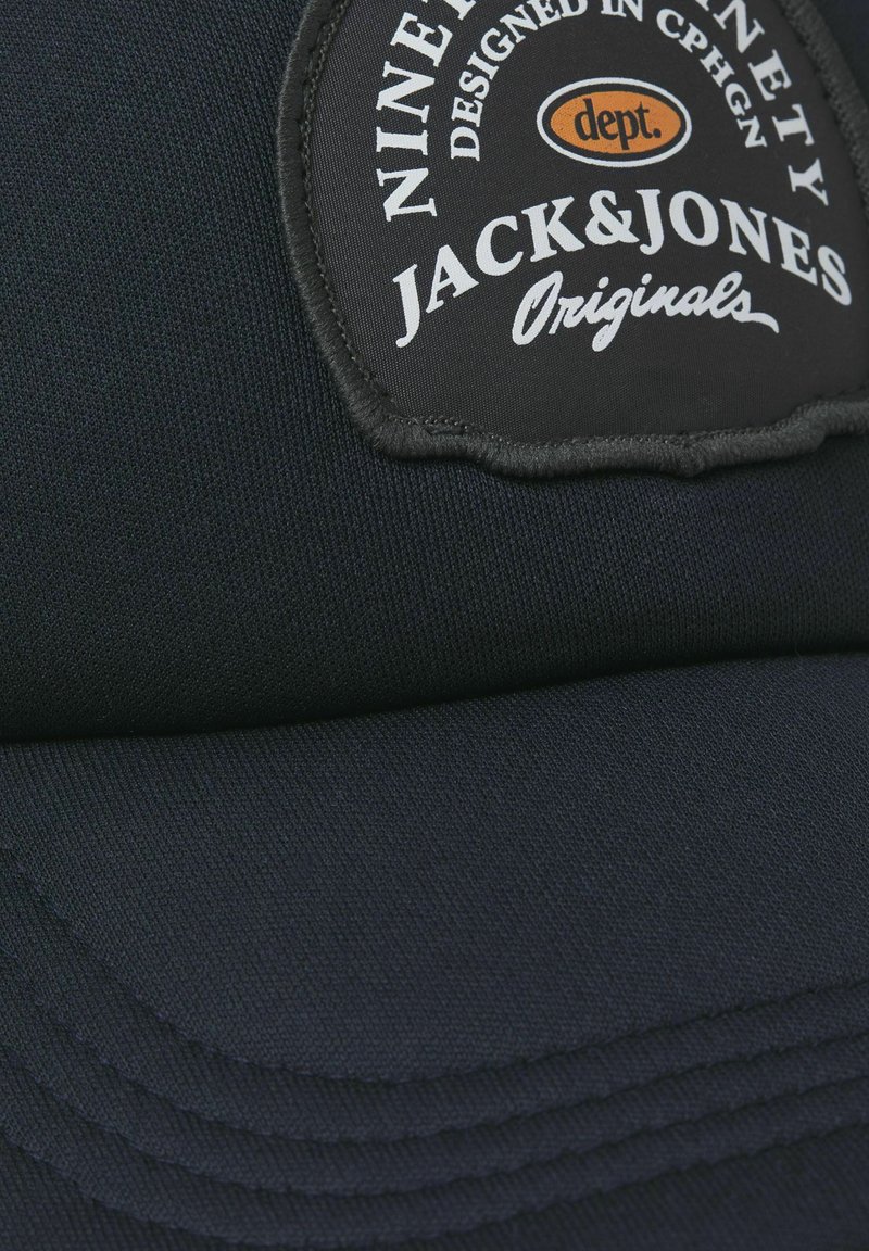 Marineblaue Kappe aus strukturiertem Stoff mit einem schwarzen Logo-Patch und weißem Text, gestickten Kanten und einem gebogenen Schirmdesign.