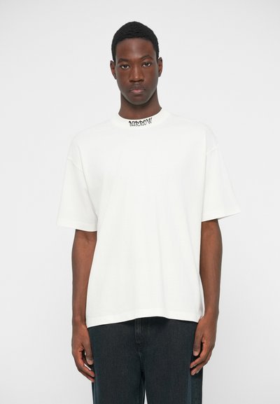 Λευκό βαμβακερό μπλουζάκι με στρογγυλή λαιμόκοψη, κοντά μανίκια και άνετη εφαρμογή. Διαθέτει μαύρο εκτυπωμένο λογότυπο στο λαιμό. Λείος υφάσματος.