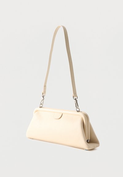 Δερμάτινη τσάντα ώμου σε κρεμ απόχρωση με μακριά λουρί και μεταλλικά κλείστρα, με μαλακό, ορθογώνιο σχήμα και κλείσιμο με πάτημα.