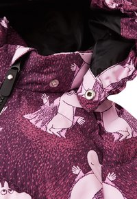 Isolierte Jacke aus pink- und lila-musterndem Stoff mit Cartoonfiguren. Enthält ein schwarzes Futter und Metalldruckknöpfe.