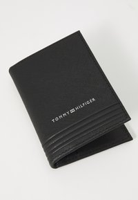 Zwarte portemonnee van gestructureerd synthetisch materiaal, met een horizontaal streepdesign en een reliëflogo. Compact, met een slanke vorm.