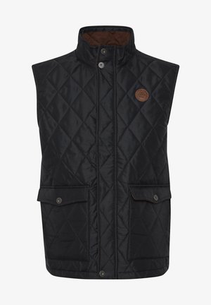 Must mustriga vest kõrge kraega, nupuväärisega ja kahe esisegmendiga taskuga. Omab pruuni voodrit ja ümarat brändi sildit rinna peal.