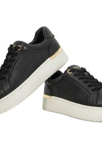Black leather sneakers feature a textured finish, gold accent on the heel, and a white platform sole with a treaded bottom.