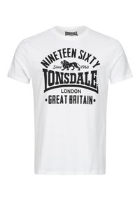 Fehér pamut póló, nagy fekete grafikával, amelyen a "Nineteen Sixty" szöveg, egy oroszlán logó és a "Lonsdale London Great Britain" felirat található.