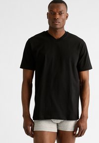 Zwarte korte mouwen V-hals t-shirt, gemaakt van katoen, met een eenvoudig ontwerp. Draagt met lichtgrijze boxershorts, minimalistische zichtbare details.