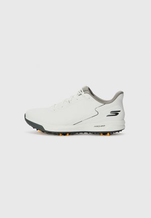 Witte sportschoen met een gladde bovenkant, grijze accenten en een gestructureerde zwarte zool met oranje spikes. Lichtgewicht ontwerp dat gericht is op comfort.