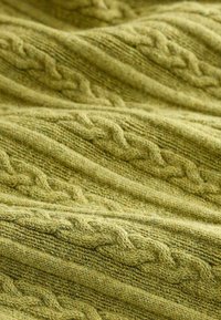 Gestrickter Pulloverstoff in gedämpftem Grün, der über strukturierte Zopfmuster und eine weiche, flauschige Oberfläche verfügt, die das filigrane Design betont.