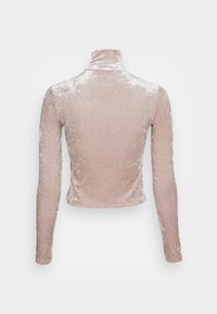 Top de cuello alto de terciopelo rosa con mangas largas, textura ligeramente arrugada y un diseño ajustado y cropped. Sin herrajes ni acentos visibles.