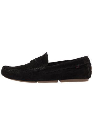 Mocasín para hombre de ante negro, tipo slip-on, con costuras tipo mocasín, suelas de goma, detalle lateral y tacón bajo.