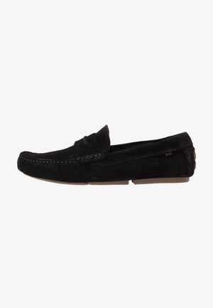 Mocasín para hombre de ante negro, tipo slip-on, con costuras tipo mocasín, suelas de goma, detalle lateral y tacón bajo.