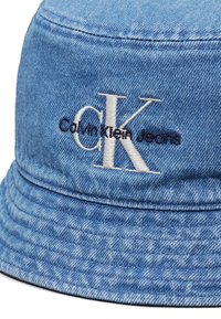 Chapeau bob en denim bleu clair avec le logo "CK" brodé en blanc et le logo "Calvin Klein Jeans" en noir, centré à l'avant.
