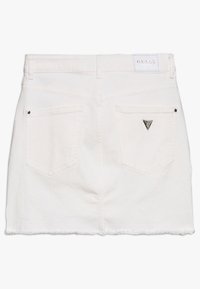 Vit denimkjol med fransad nederkant, två bakfickor och silverfärgad logoprydnad. Klassisk design med minimalistiska detaljer. Tillverkad i bomull.