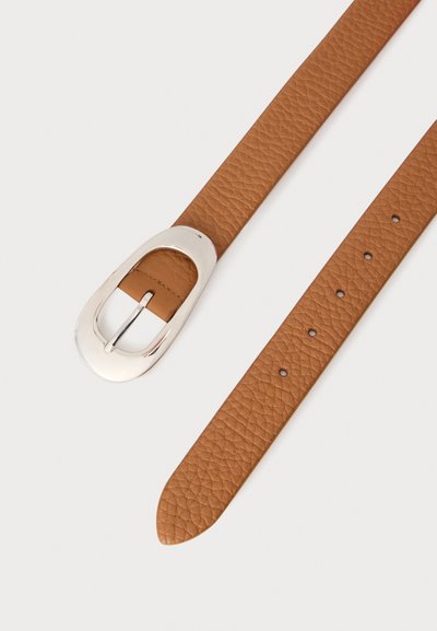 Ceinture en cuir marron texturé avec une grande boucle ovale argentée et plusieurs trous de réglage sur fond blanc.