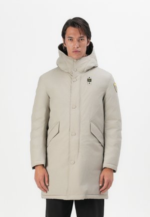 Parka grigia imbottita con colletto alto, chiusura frontale con bottoni, due tasche laterali e un patch logo sul petto sinistro. Texture liscia.