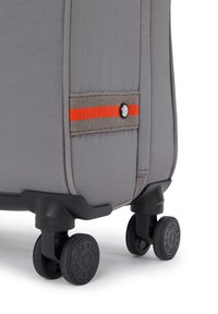 Gray suitcase with a textured surface, featuring an orange stripe and black wheels with embossed designs. Compact and streamlined shape.