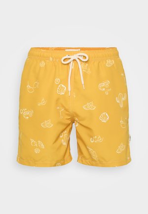Gule svømmebukser med hvite kyst-tema trykk, med snor i midjen og glatt, lett stoff.