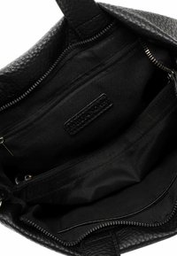 Mustast nahast õlakott tekstureeritud välispinnaga, millel on tõmblukk, mitu sisetaskut ja voodriga kangastosa.