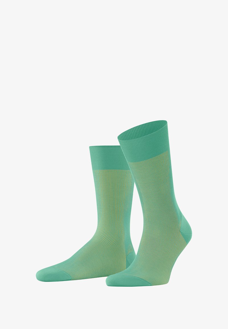 Jasnozielone skarpetki wykonane z gładkiego, elastycznego materiału. Posiadają prążkowane wykończenie na górze, bezszwowe palce oraz subtelny wzór w jaśniejszym odcieniu zieleni.