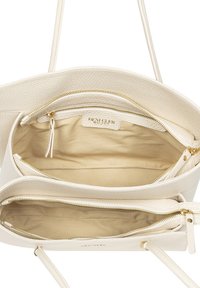 Biała skórzana torebka na ramię z podwójnymi zamkami błyskawicznymi, gładką fakturą, złotymi akcentami i przestronnym wnętrzem wyłożonym beżową podszewką.