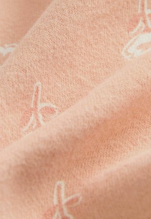 Helle rosa Stoff mit einer weichen Textur und subtilem weißen Muster, das eine Mischung aus glatten und plüschigen Fasern zeigt.