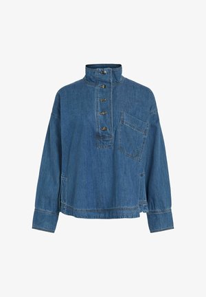 Denim džemperis ar augstu apkakli, pieciem metāla pogām, krūšu kabatu un sānu šķēlumiem. Vidēji zila mazgāšana ar nedaudz strukturētu virsmu.