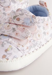 Scarpine da neonato rosa chiaro con motivo floreale, cinturini in velcro e suola in gomma bianca. Fodera interna morbida azzurra per il massimo comfort.