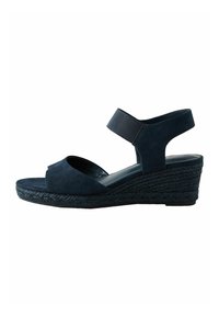 Mørkeblå kile-sandal med en struktureret ruskindsoverdel, åben tå og en justerbar rem omkring anklen. Korklignende platåsål.