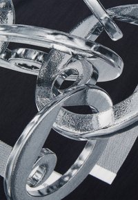 Graphique métallique de boucles et spirales entrelacées avec une surface brillante sur un fond sombre, présentant des accents texturés et lisses.