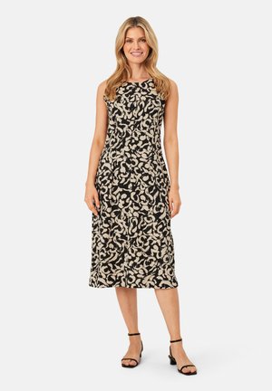 Robe midi sans manches noire avec un motif abstrait blanc. Le tissu semble léger avec une texture lisse. Sandales noires à bride de cheville.