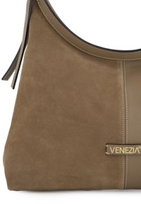 Sac hobo en daim marron et cuir lisse, avec un design cousu et une étiquette de marque. Texture douce avec une forme arrondie et une bandoulière réglable.