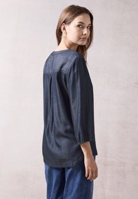 Denim-Oberteil mit Dreiviertelärmeln, dunkelblauer Farbe, lockerer Passform, Rückenfalte, weichem Material und rundem Ausschnitt.