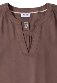Blouse marron pour femmes avec un décolleté en V, un détail plissé sous le cou, et deux étiquettes en tissu portant les mentions "CECIL" et "sea SIDE".