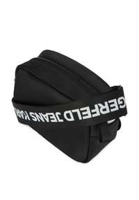 Geantă neagră din nailon cu formă triunghiulară, prevăzută cu închidere cu fermoar și o banderolă lată marcată cu inscripția "GERFELD JEANS" în litere albe.