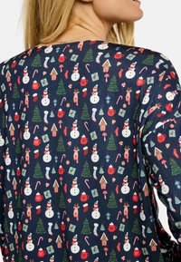 Tengerészkék szövet ismétlődő karácsonyi motívumokkal: hóemberek, jávorszarvasok, karácsonyfák, ajándékok, cukorpálcikák, mézeskalács házikók, bögrék és zoknik.