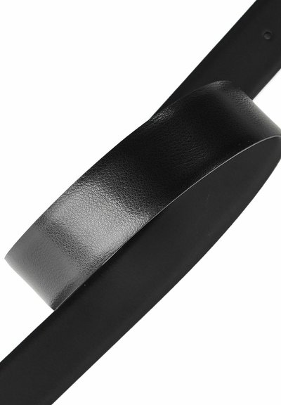 Cinturón negro de cuero doblado sobre un fondo blanco liso, mostrando superficie texturizada y lado interior liso.