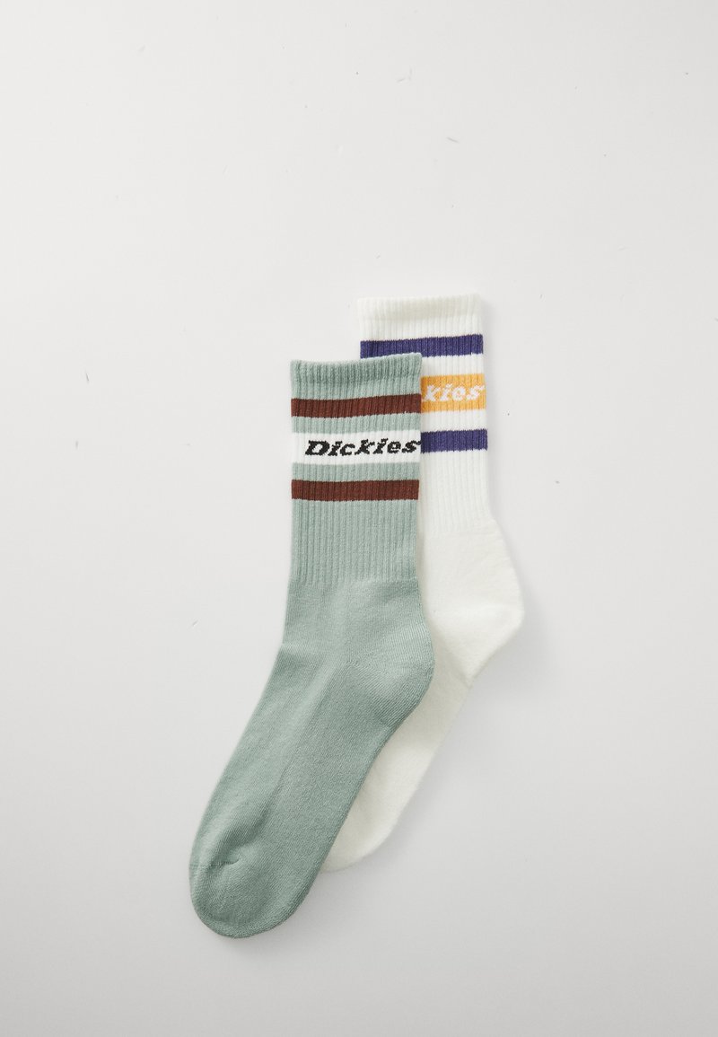 Two pairs of crew socks: one mint green with brown and white stripes featuring "Dickies," and one white, striped in purple and orange.