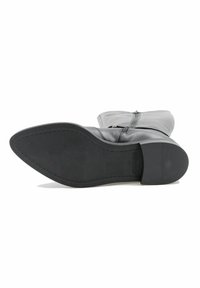 Botine negre din piele, cu vârf rotunjit, textură netedă, închidere cu fermoar și talpă solidă din cauciuc cu un toc ușor.