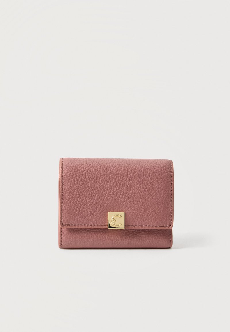 Portefeuille compact en cuir texturé rose poudré avec un fermoir carré doré comportant un C embossé sur fond blanc.
