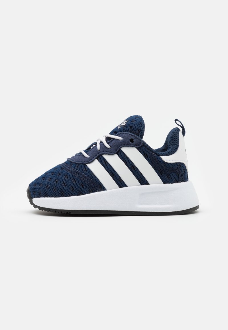 Sneaker atletica blu navy e bianca con tomaia in mesh, tre strisce bianche sui lati, lacci bianchi, suola spessa bianca e suola esterna nera.