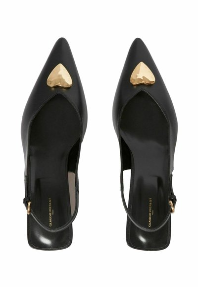 Escarpins slingback en cuir noir avec bouts pointus, présentant un accent en forme de cœur doré sur le dessus. Texture lisse et fine bride de cheville.