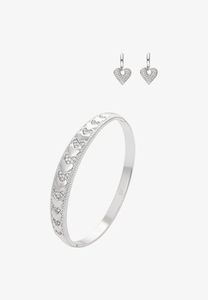 Zilveren armband met hartpatronen en kleine ingelegde steentjes, gecombineerd met hartvormige oorbellen met vergelijkbare steenaccenten.