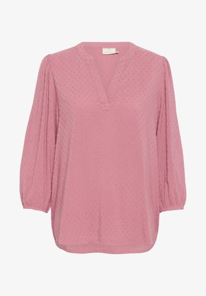 Svetlo roza bluzica z v-izrezom, dolgimi napihnjenimi rokavi in teksturirano tkanino s pikami. Okrogla robna linija in subtilni šivi.