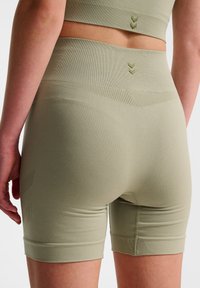 Höga, olivgröna sömlösa shorts i ett stretchigt material med subtil textur, med en längd till mitten av låret och minimal detaljering.