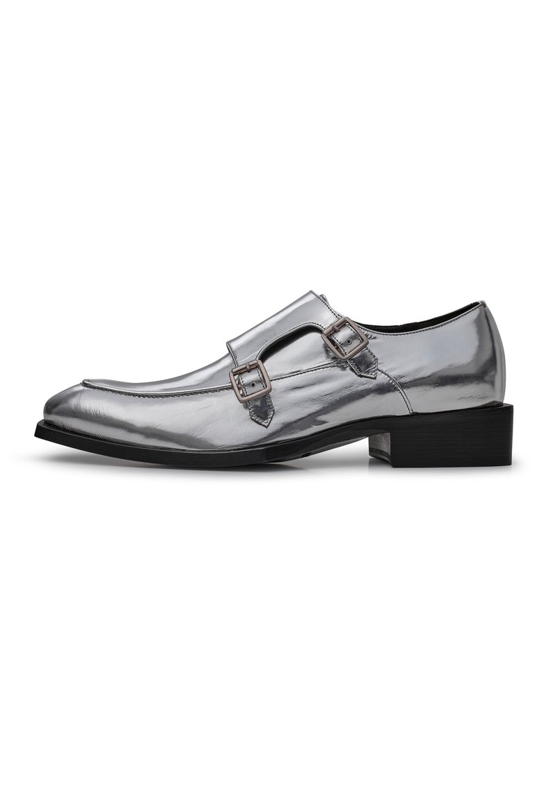 Silberne Lacklederschuhe mit spitz zulaufender Zehenpartie und doppeltem Schnallenakzent. Sie verfügen über einen niedrigen schwarzen Absatz und eine glatte, glänzende Oberflächenstruktur.