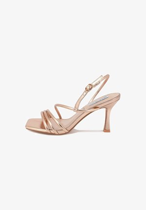 Metallic rose gold heeled sandal with a square toe and thin straps, featuring an adjustable ankle strap and a tapered heel.