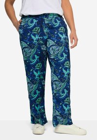Pantaloni con motivo paisley blu in un tessuto leggero, con accenti floreali verdi, tasche laterali e una vestibilità rilassata. Abbinati a sneakers bianche.
