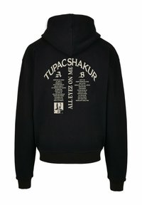 Schwarzer Hoodie mit einem großen beigen Grafikdruck auf der Rückseite mit "TUPAC SHAKUR" und Songtexten, aus weichem Stoff mit verstellbarer Kapuze.
