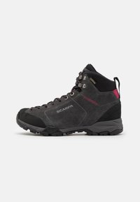 Botas de senderismo gris con puntera de goma negra, ojales de metal y acentos en rosa. Fabricadas en ante y cuentan con un cuello texturizado en negro.
