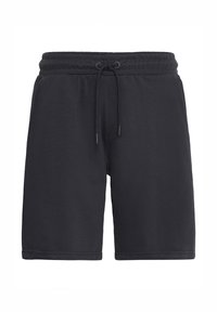 Mustad spordipüksid lõdva lõikega, millel on elastne vöökoht paelaga ja sile tekstuur. Taskuid pole nähtaval.